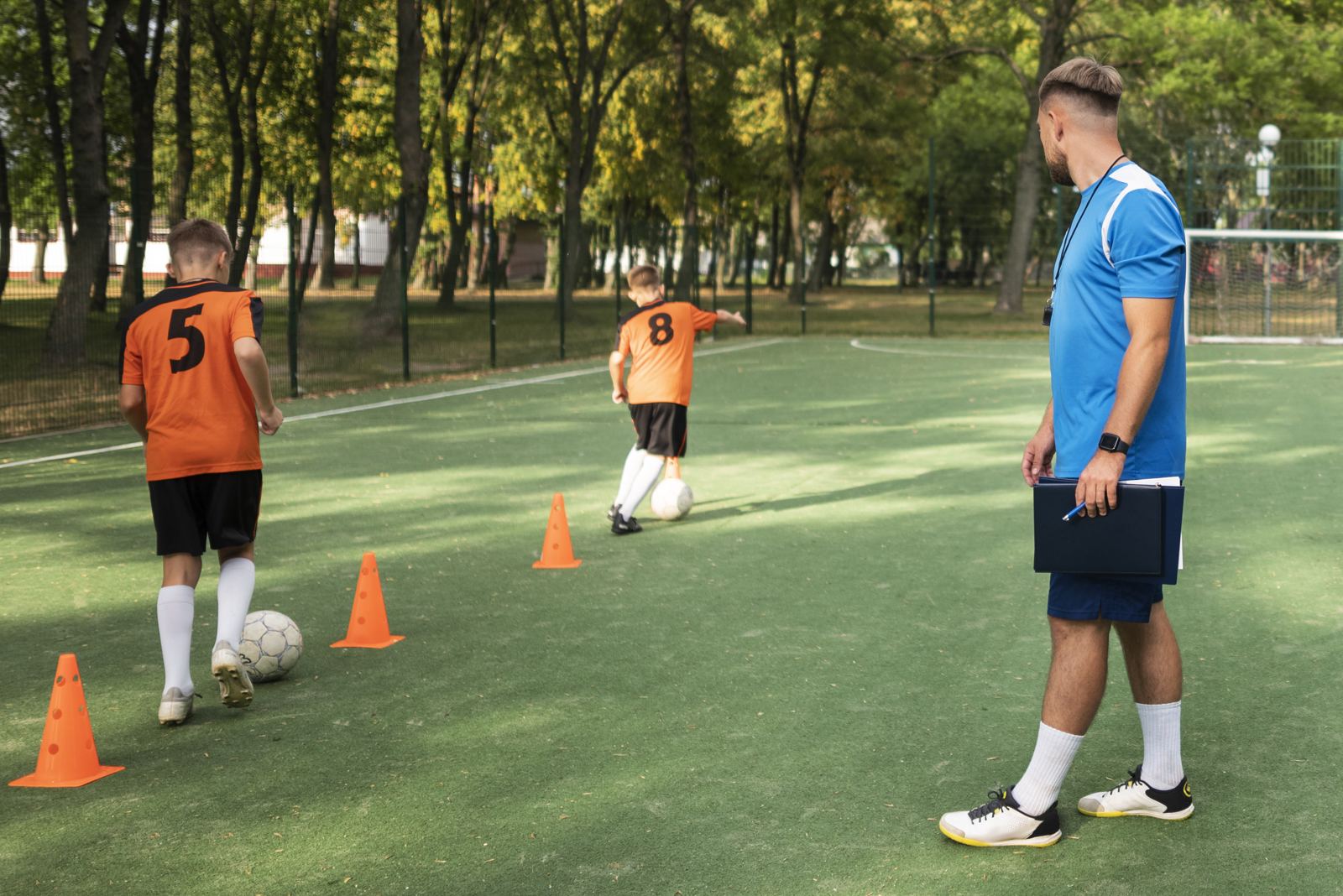 Trainer geeft uitleg aan jeugdspelers
