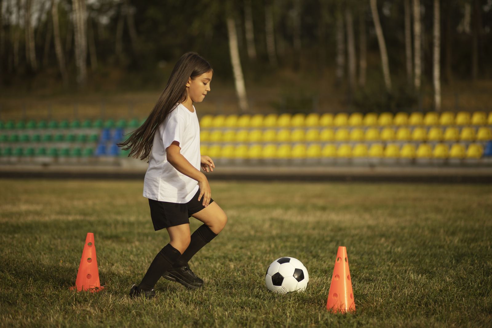 Kinderen spelen voetbal onder begeleiding van een trainer
